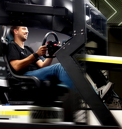 Fahrer im ZEEEM RACR R PERFORMANCE mit Motion System für realistische Fahrzeugbewegungen.